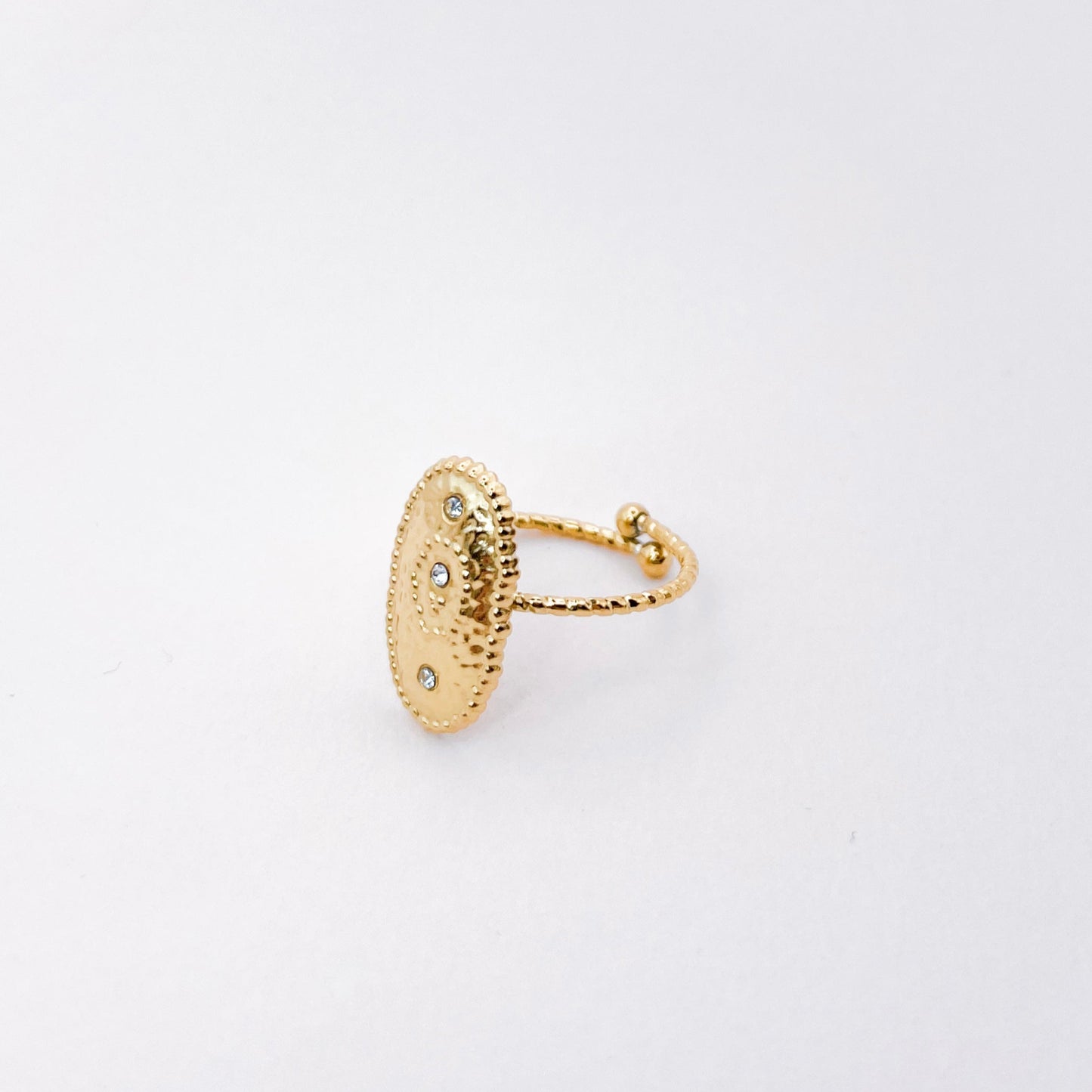 bague texturée. anneau fin réhaussé d'un oval martelé avec 3 strass incrustés